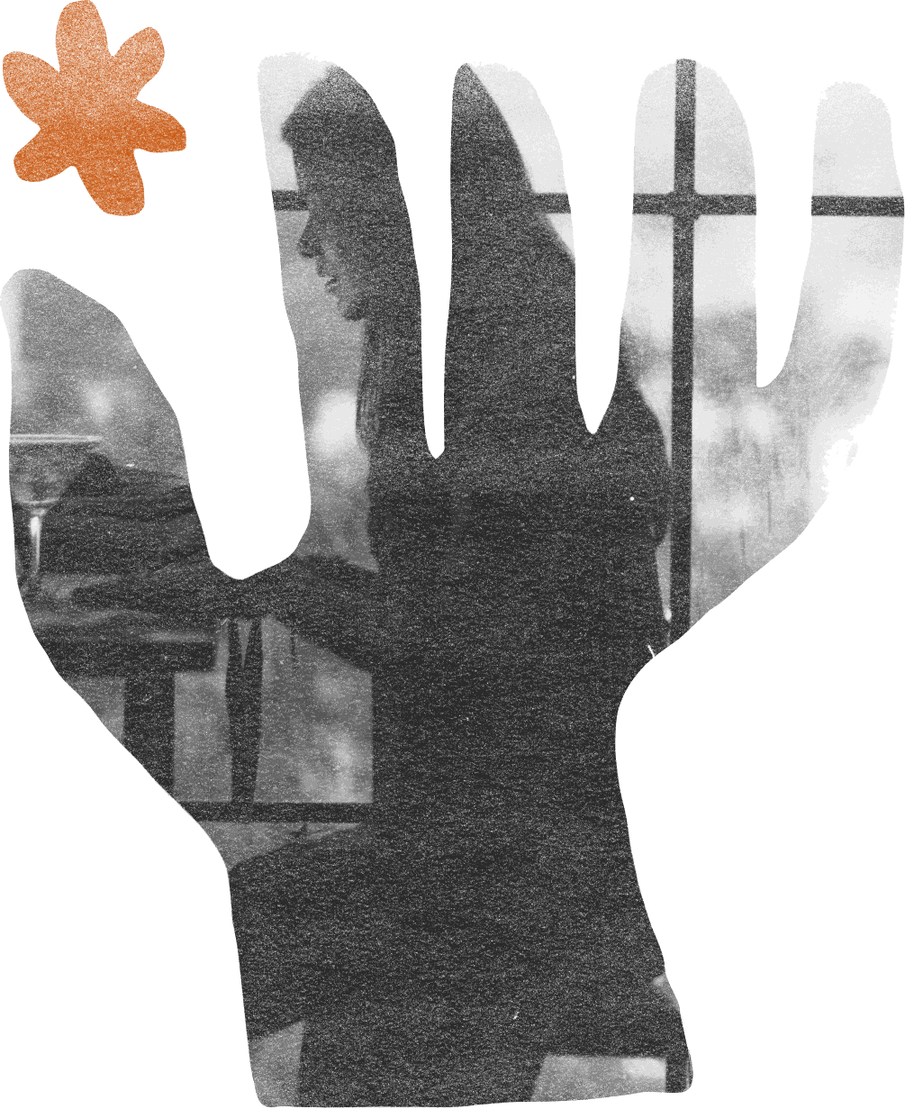 Black-and-white photograph of a window cut into the shape of an open hand, with a small burnt orange flower beside it