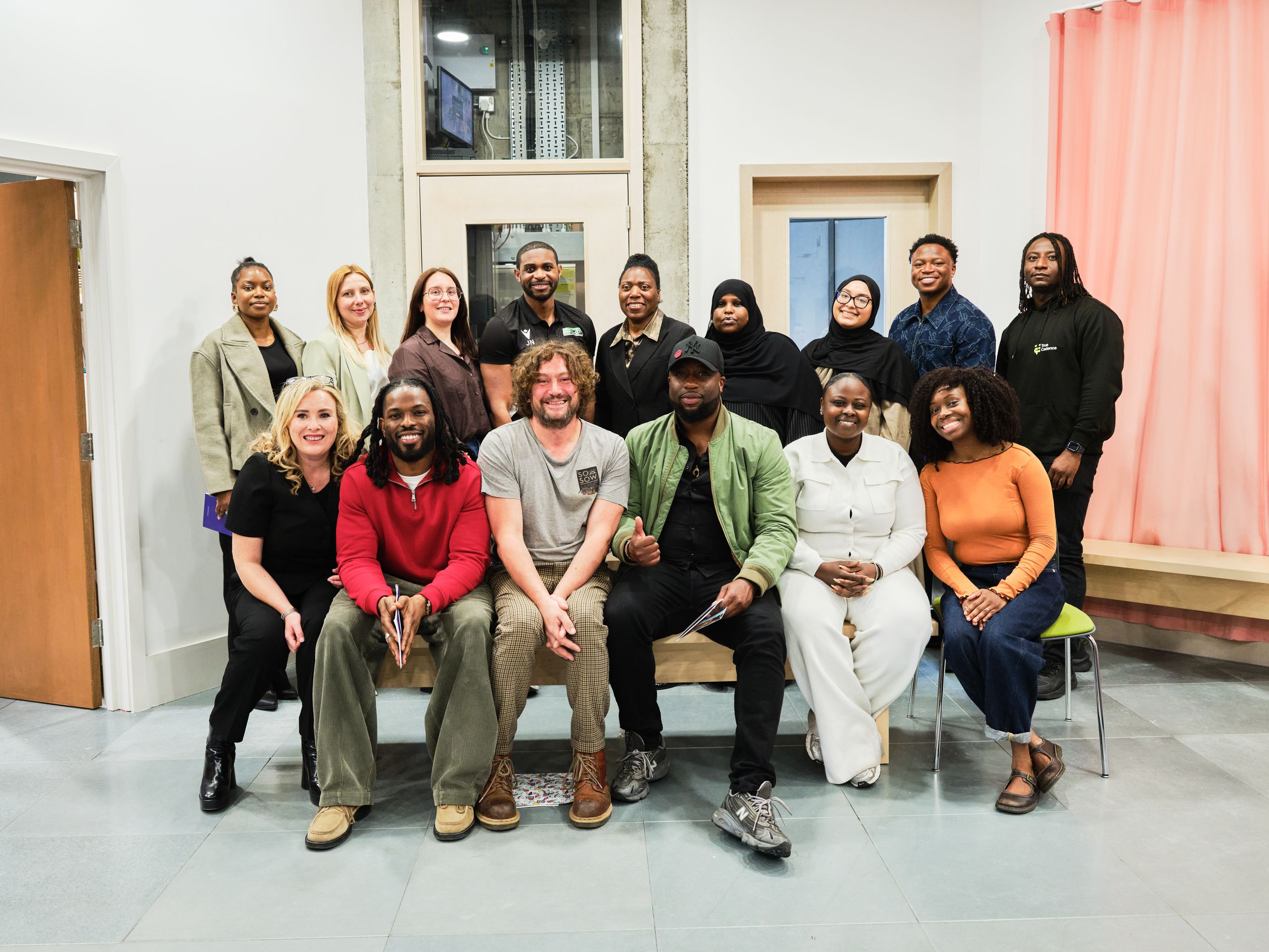 The GROW 2026 cohort, around twenty people, posed in two rows in a bright room